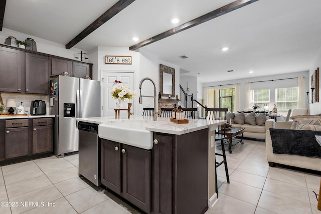 79 Coastline Way, Saint Augustine, FL 32092 - kitchen featuring a breakfast bar, appliances with stainless steel finishes, open floor plan, backsplash, and light tile patterned floors