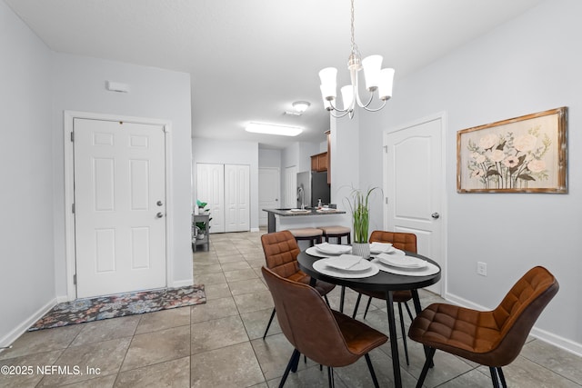 dining room with light tile patterned flooring, baseboards, and a notable chandelier