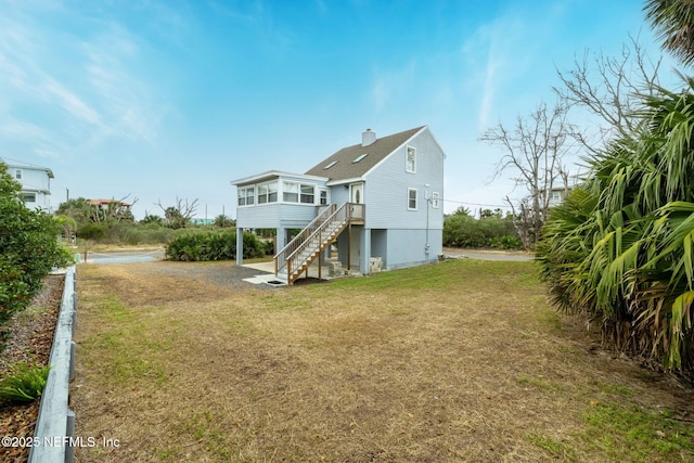27 Flagler Dr, Palm Coast, FL 32137 - back of house featuring stairway, a yard, a sunroom, and a chimney