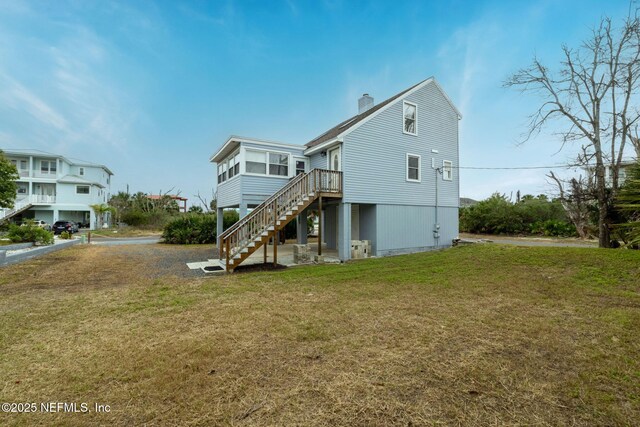 27 Flagler Dr, Palm Coast, FL 32137 - rear view of property with stairway, a yard, and a chimney