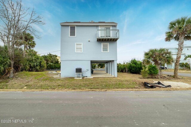 27 Flagler Dr, Palm Coast, FL 32137 - back of property with a yard, central AC, and a balcony