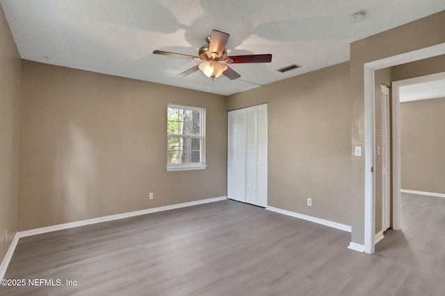 4245 New Hampshire Rd, Elkton, FL 32033 - unfurnished bedroom featuring wood finished floors, a closet, baseboards, and visible vents