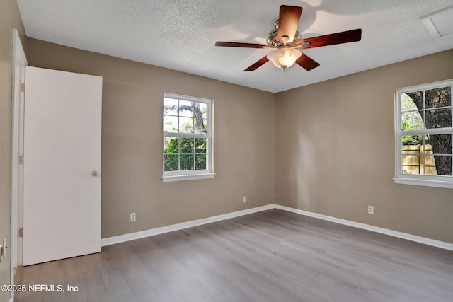 4245 New Hampshire Rd, Elkton, FL 32033 - unfurnished bedroom with baseboards, a ceiling fan, wood finished floors, and a textured ceiling
