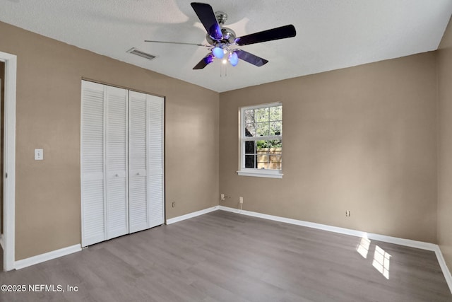 4245 New Hampshire Rd, Elkton, FL 32033 - unfurnished bedroom with baseboards, visible vents, a ceiling fan, a closet, and wood finished floors