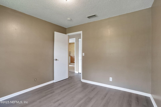 4245 New Hampshire Rd, Elkton, FL 32033 - empty room with wood finished floors, a textured ceiling, baseboards, and visible vents