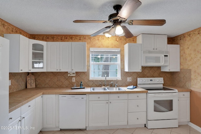 4245 New Hampshire Rd, Elkton, FL 32033 - kitchen featuring white cabinetry, wallpapered walls, a sink, and white appliances