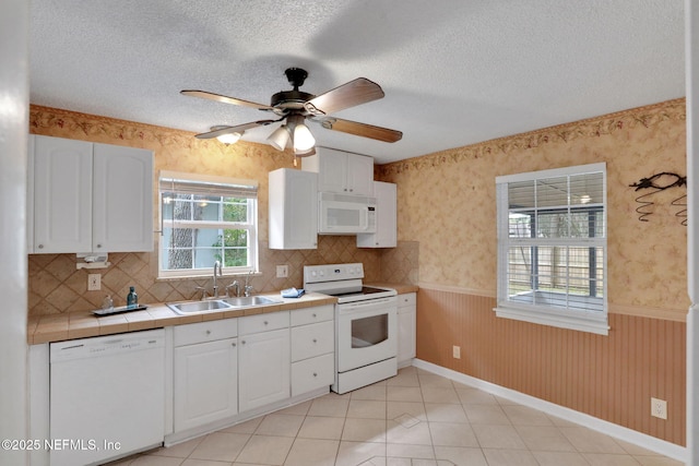 4245 New Hampshire Rd, Elkton, FL 32033 - kitchen with white appliances, wainscoting, wallpapered walls, and a sink