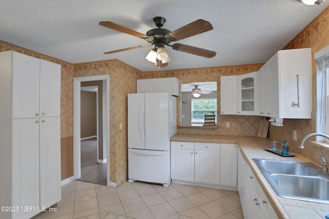 4245 New Hampshire Rd, Elkton, FL 32033 - kitchen featuring white cabinetry, a sink, tile countertops, freestanding refrigerator, and a ceiling fan