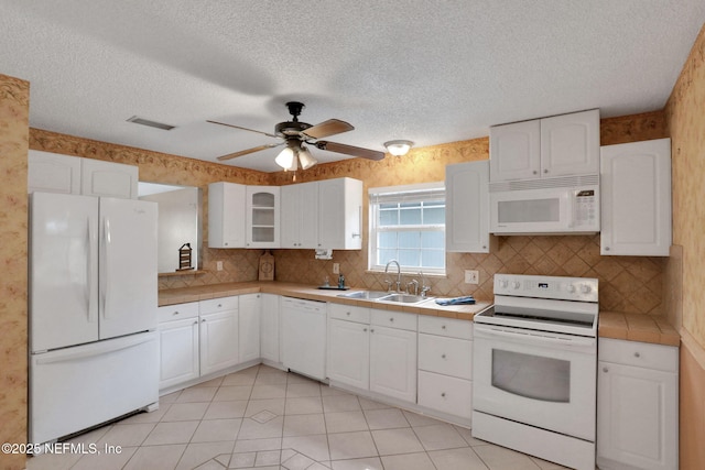 4245 New Hampshire Rd, Elkton, FL 32033 - kitchen featuring tile counters, white appliances, white cabinets, and a sink