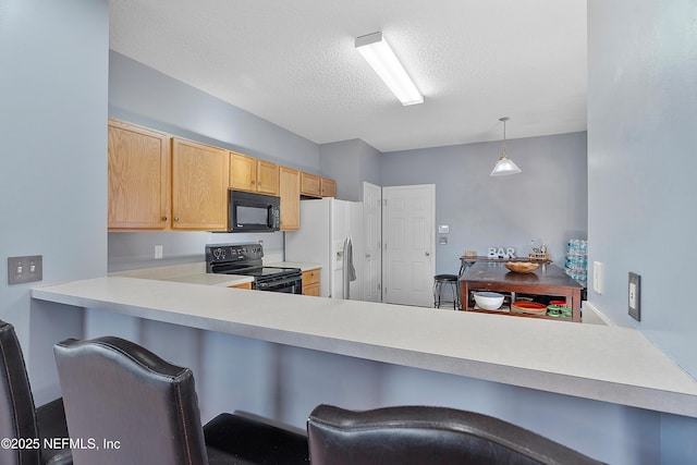 kitchen featuring a textured ceiling, light countertops, a peninsula, black appliances, and a kitchen breakfast bar