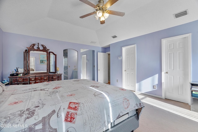 bedroom with lofted ceiling, carpet flooring, arched walkways, visible vents, and a ceiling fan