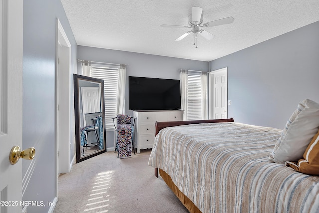 bedroom with light carpet, ceiling fan, and a textured ceiling