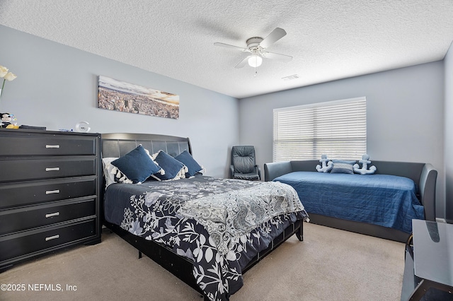 carpeted bedroom featuring visible vents, a ceiling fan, and a textured ceiling