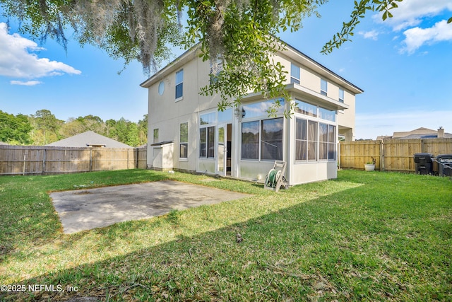 rear view of property with a lawn, a fenced backyard, stucco siding, and a patio area