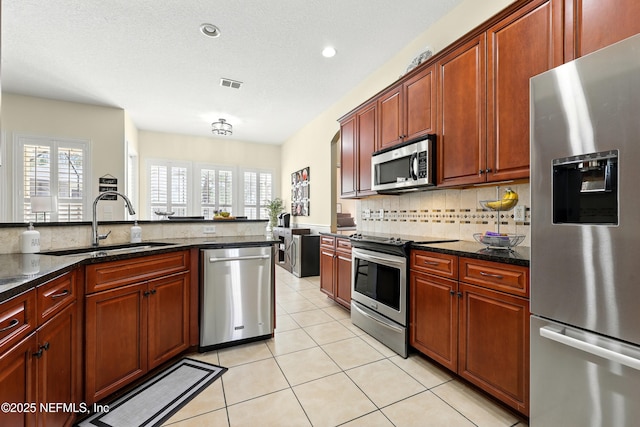 kitchen featuring appliances with stainless steel finishes, a sink, tasteful backsplash, plenty of natural light, and recessed lighting