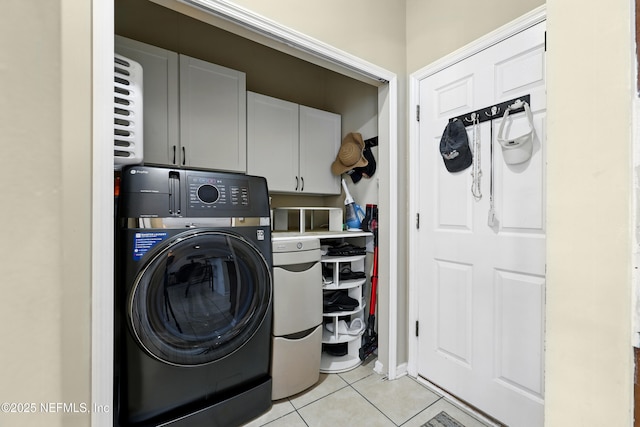 laundry room featuring washer / dryer, cabinet space, and light tile patterned floors