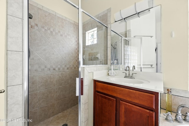 full bath with a stall shower and vanity