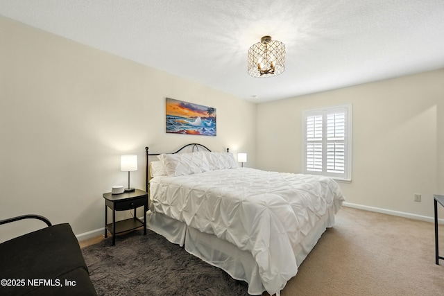 carpeted bedroom with a chandelier and baseboards