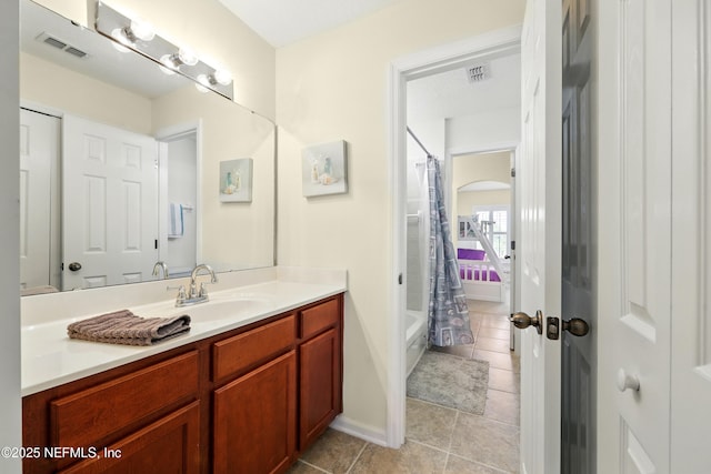 full bath featuring tile patterned flooring, vanity, shower / tub combo, and baseboards