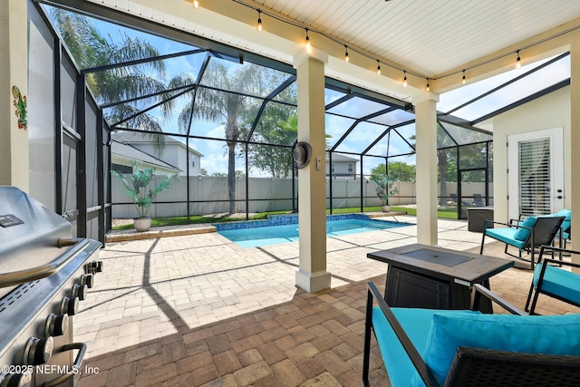 view of swimming pool with a patio, a lanai, a grill, and a fenced backyard