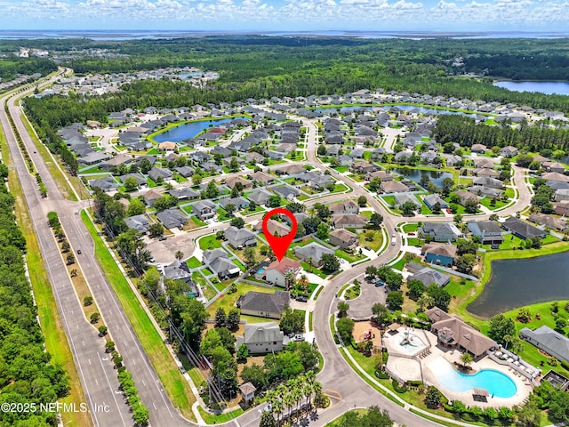 view of property location with a large body of water, a pool, and nearby suburban area