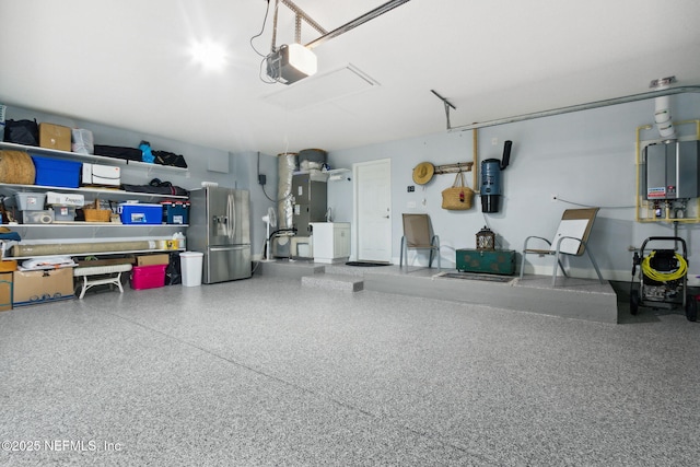 95150 Starling Ct, Fernandina Beach, FL 32034 - garage featuring stainless steel fridge, a garage door opener, a central vacuum unit, heating unit, and tankless water heater