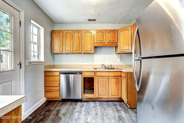 979 Mikael Ave, Jacksonville, FL 32205 - kitchen with appliances with stainless steel finishes, a sink, light countertops, wood finished floors, and a textured ceiling