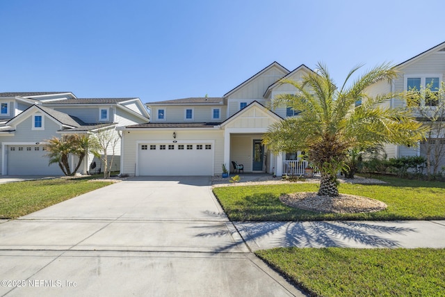 view of front of property featuring an attached garage, board and batten siding, driveway, a front lawn, and covered porch