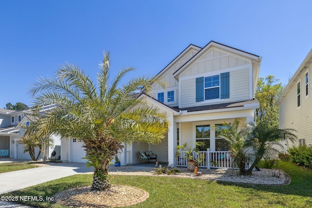 view of front of home featuring an attached garage, board and batten siding, driveway, a front lawn, and covered porch