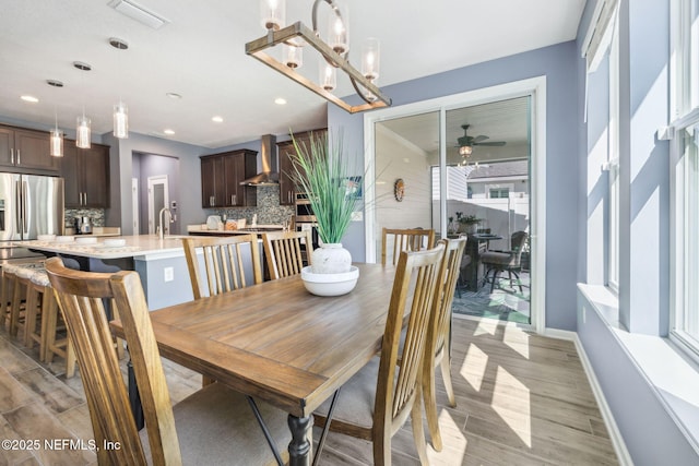 dining space featuring a ceiling fan, light wood-style flooring, baseboards, and visible vents