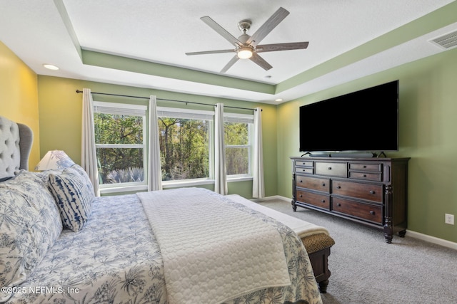 bedroom with carpet, baseboards, a tray ceiling, and visible vents