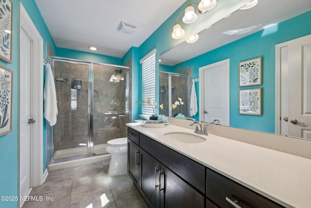 bathroom featuring toilet, vanity, a shower stall, tile patterned flooring, and visible vents