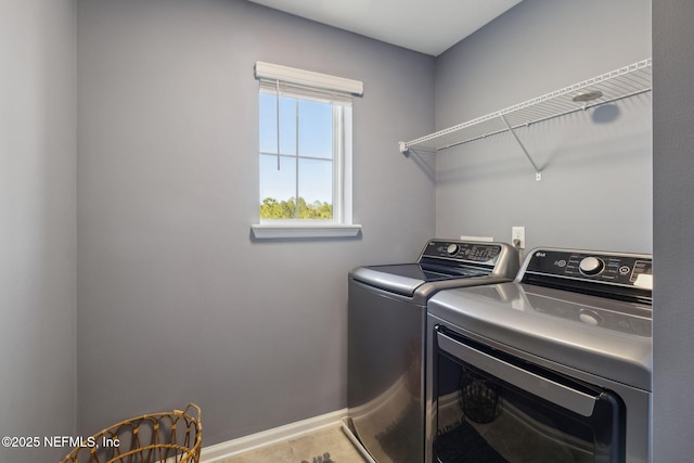 clothes washing area featuring independent washer and dryer, laundry area, and baseboards