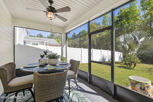 sunroom / solarium with a ceiling fan and outdoor dining space