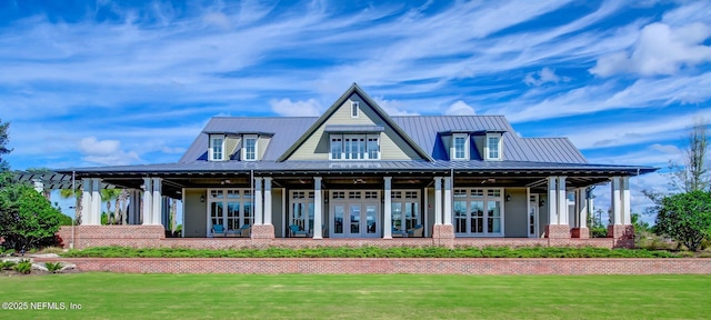 back of property with metal roof, french doors, and a yard