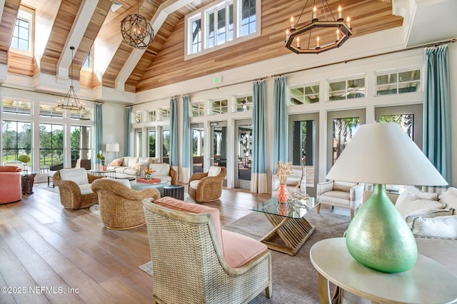 sunroom / solarium featuring an inviting chandelier, a healthy amount of sunlight, and beamed ceiling