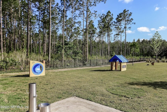 view of community featuring fence and a yard