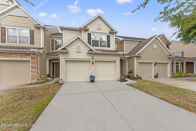 11066 Castlemain Cir, Jacksonville, FL 32256 - view of property featuring an attached garage, concrete driveway, and stone siding