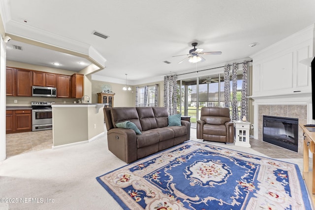 11066 Castlemain Cir, Jacksonville, FL 32256 - living room featuring crown molding, a tiled fireplace, a ceiling fan, recessed lighting, and visible vents