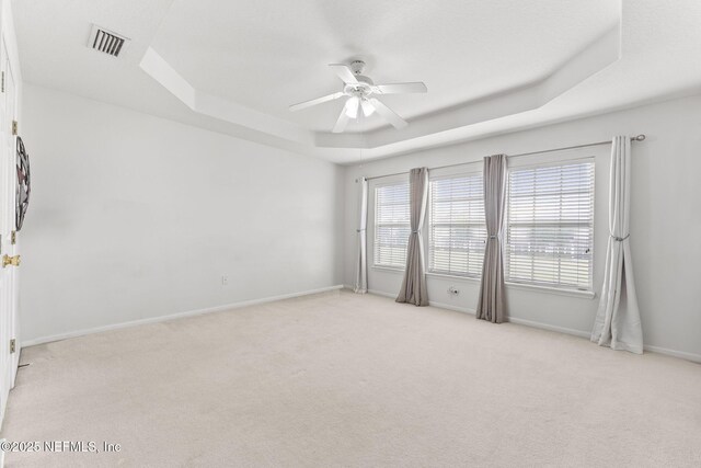 11066 Castlemain Cir, Jacksonville, FL 32256 - empty room with light colored carpet, a tray ceiling, visible vents, and a ceiling fan