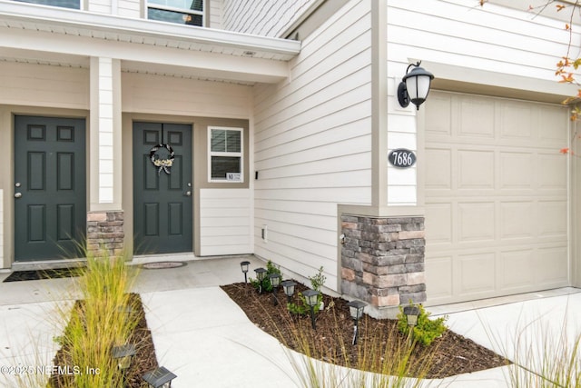7686 Merchants Way, Jacksonville, FL 32222 - view of exterior entry featuring stone siding, a garage, and a porch