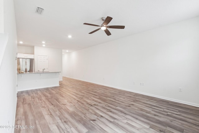 7686 Merchants Way, Jacksonville, FL 32222 - unfurnished living room featuring baseboards, visible vents, light wood-style flooring, and a ceiling fan
