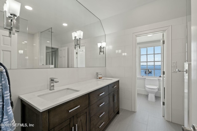 1301 Redbud Ln, Jacksonville, FL 32207 - full bathroom with tile walls, tile patterned flooring, double vanity, a water view, and toilet