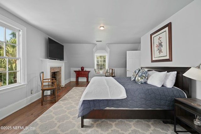 1301 Redbud Ln, Jacksonville, FL 32207 - bedroom featuring wood finished floors, baseboards, and a brick fireplace