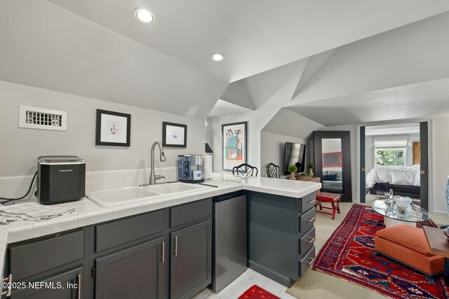 1301 Redbud Ln, Jacksonville, FL 32207 - kitchen with a sink, lofted ceiling, a peninsula, gray cabinets, and recessed lighting