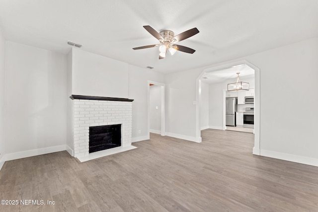 4651 Polaris St, Jacksonville, FL 32205 - unfurnished living room with ceiling fan with notable chandelier, a fireplace, baseboards, and light wood-type flooring