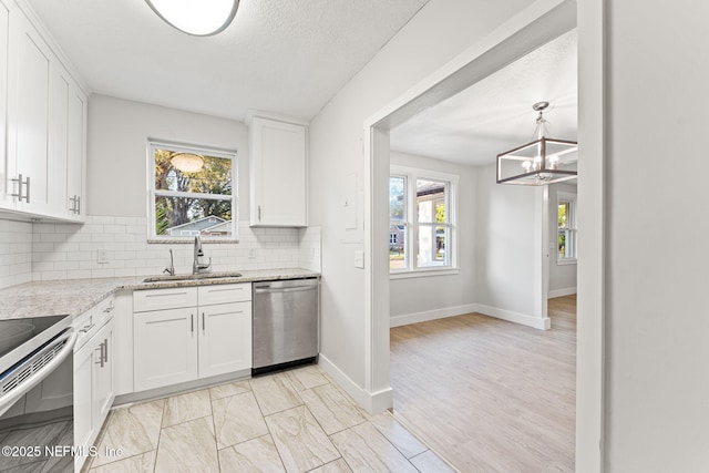 4651 Polaris St, Jacksonville, FL 32205 - kitchen featuring decorative backsplash, white cabinetry, a sink, range with electric stovetop, and stainless steel dishwasher
