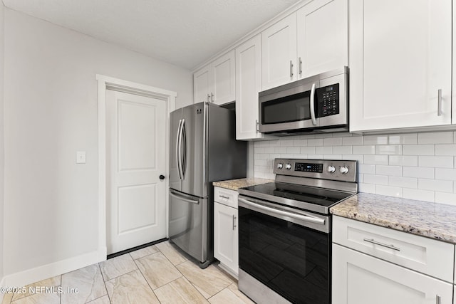 4651 Polaris St, Jacksonville, FL 32205 - kitchen featuring white cabinetry, tasteful backsplash, appliances with stainless steel finishes, and light stone counters