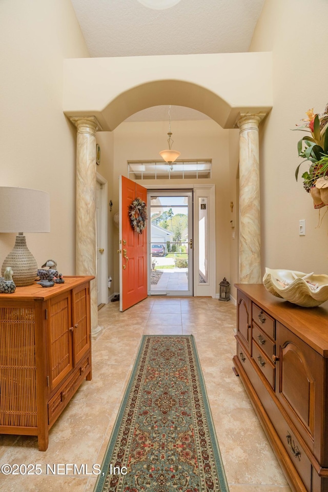784 Crestwood Dr, Saint Augustine, FL 32086 - foyer featuring baseboards, vaulted ceiling, arched walkways, and ornate columns