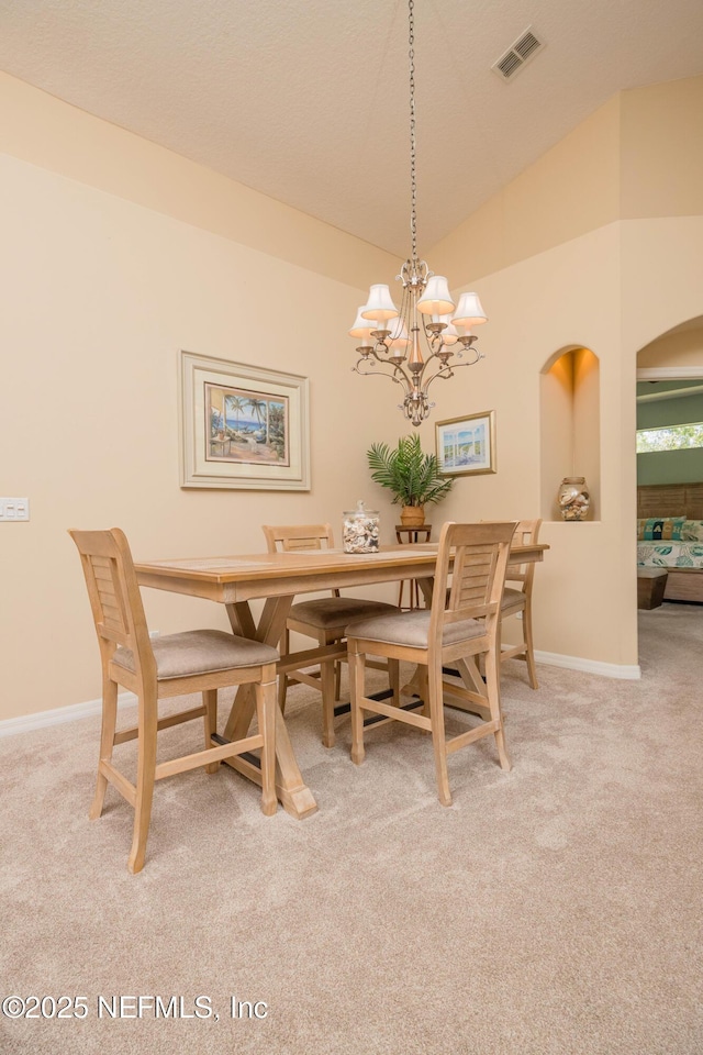 784 Crestwood Dr, Saint Augustine, FL 32086 - carpeted dining room with visible vents, a chandelier, baseboards, arched walkways, and lofted ceiling